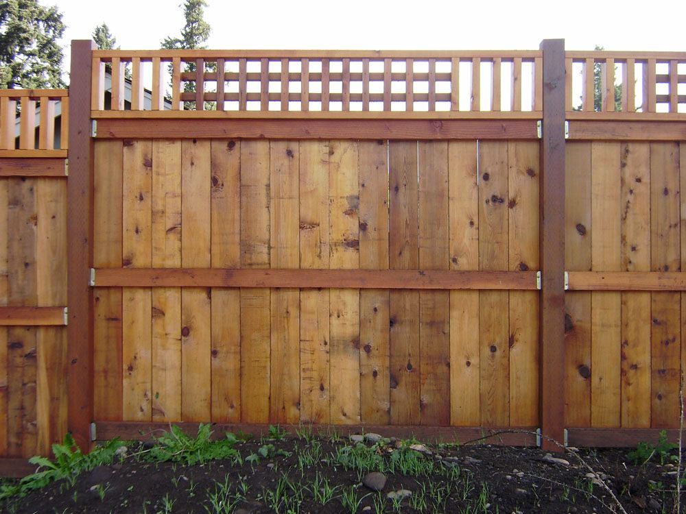 A wooden fence with a trellis on top of it