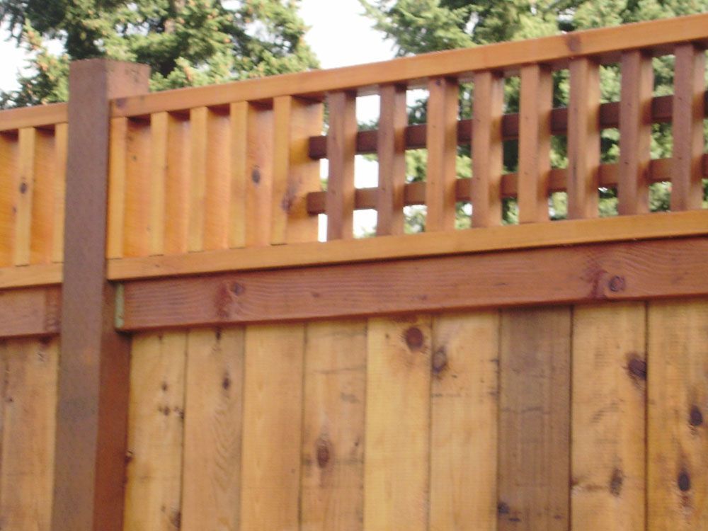 A close up of a wooden fence with trees in the background
