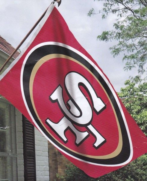 A san francisco 49ers flag is hanging from a pole