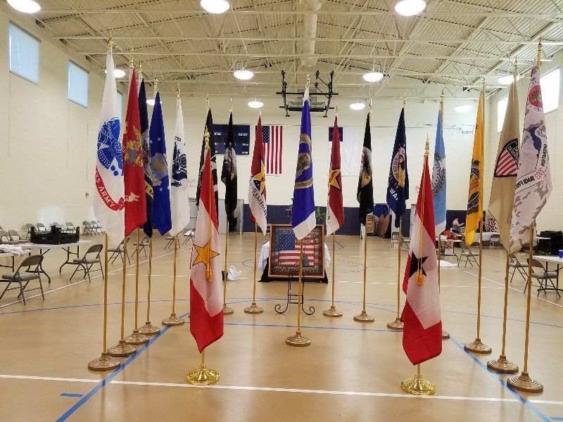 A row of flags are lined up in a gym.