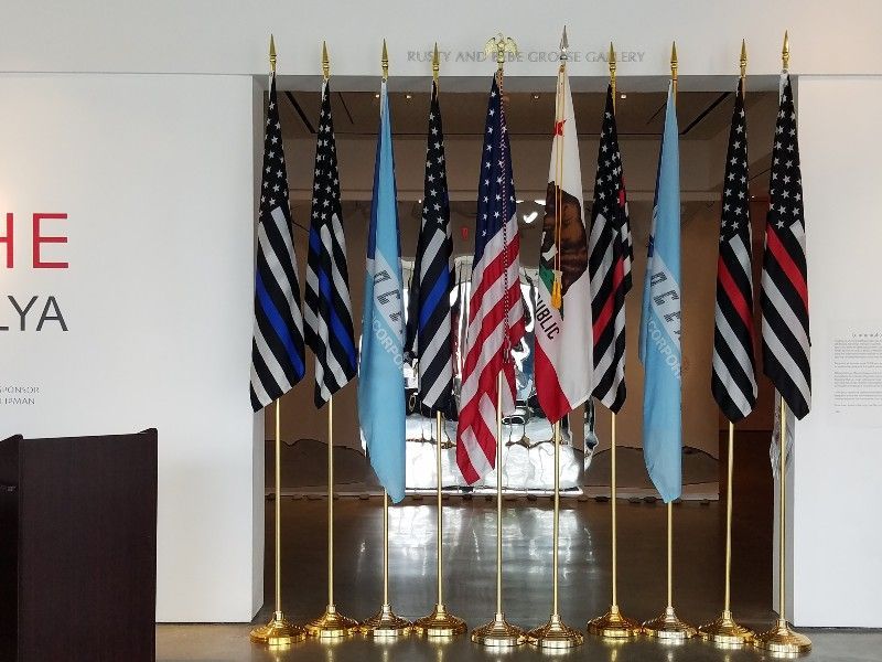 A row of flags in front of a wall that says he ya