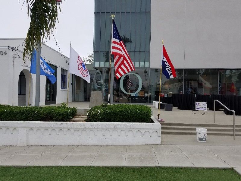 A few flags are flying in front of a building