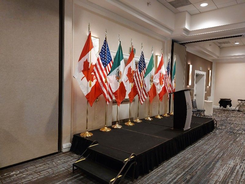 A room with a stage and flags on it