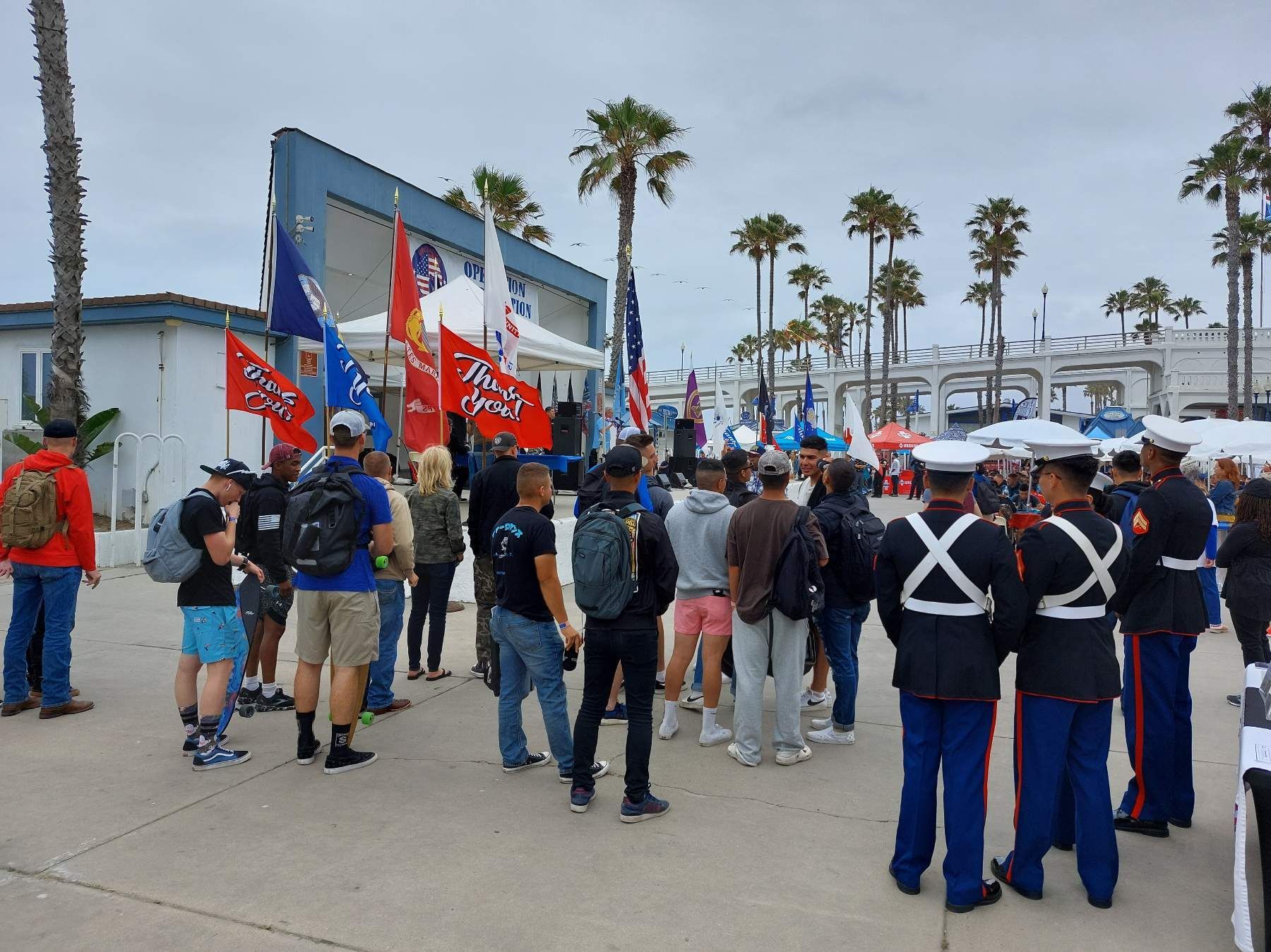 A group of people standing in front of a building with flags