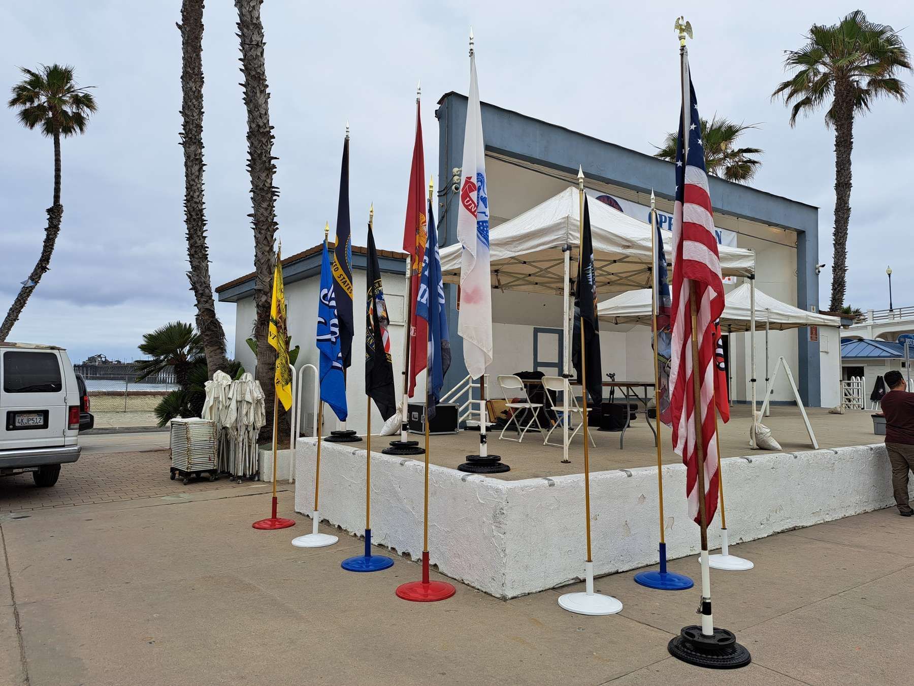 A row of flags are lined up in front of a building