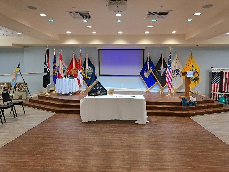 A large room with a stage and flags on it