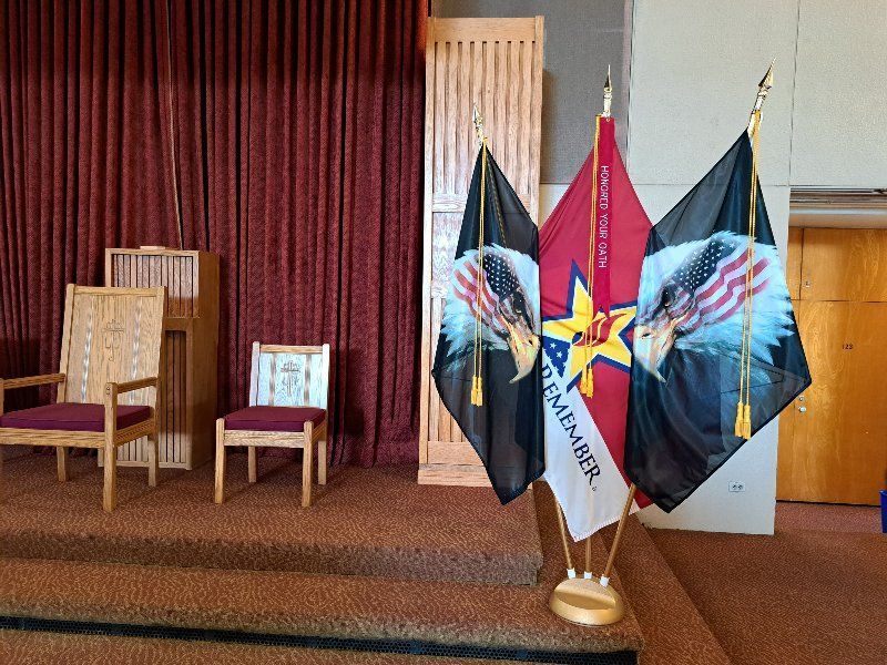 Three flags are displayed in a church with one that says texas member