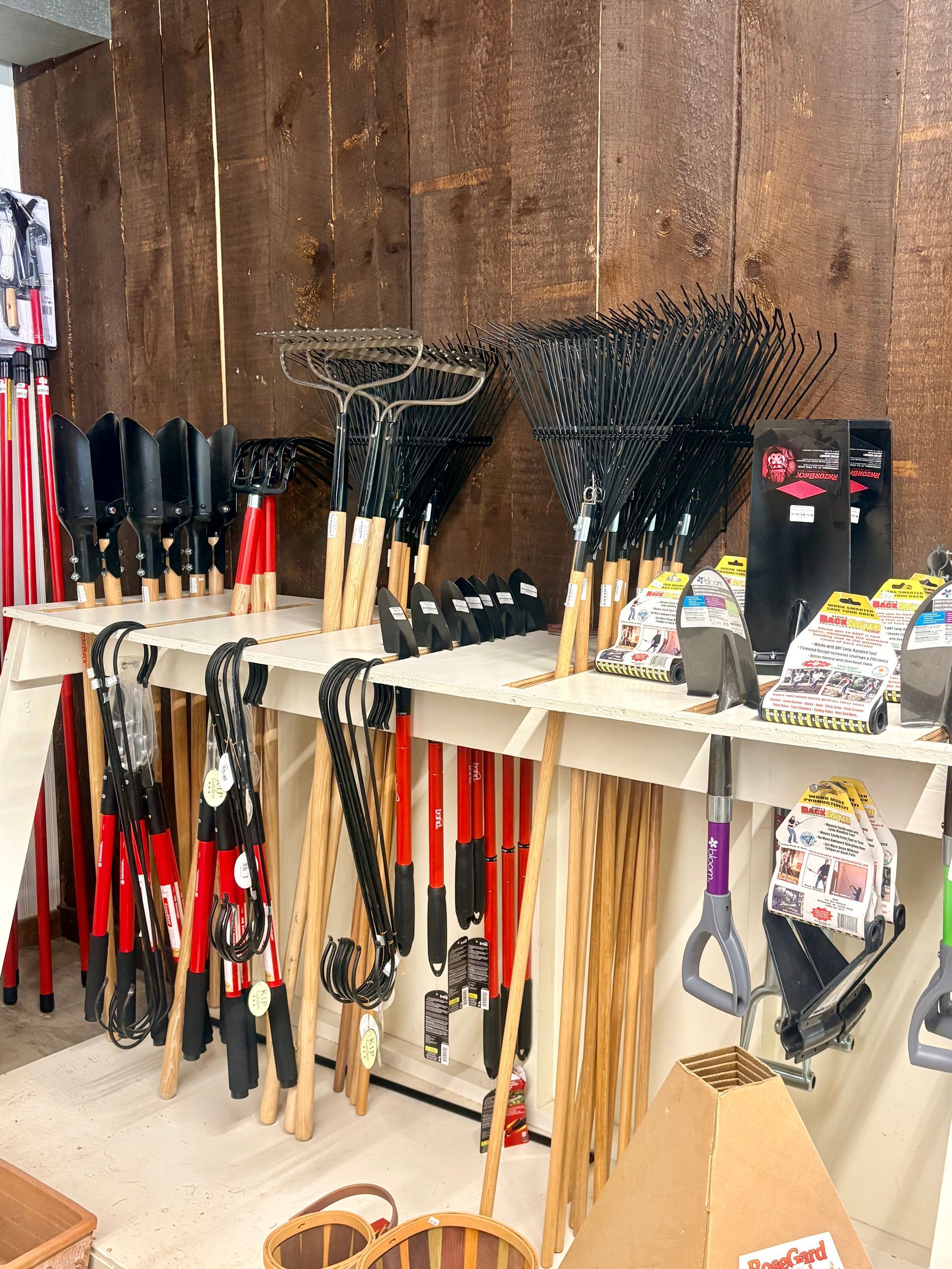 Assorted fishing nets and tools hanging on a wooden wall in a shop display