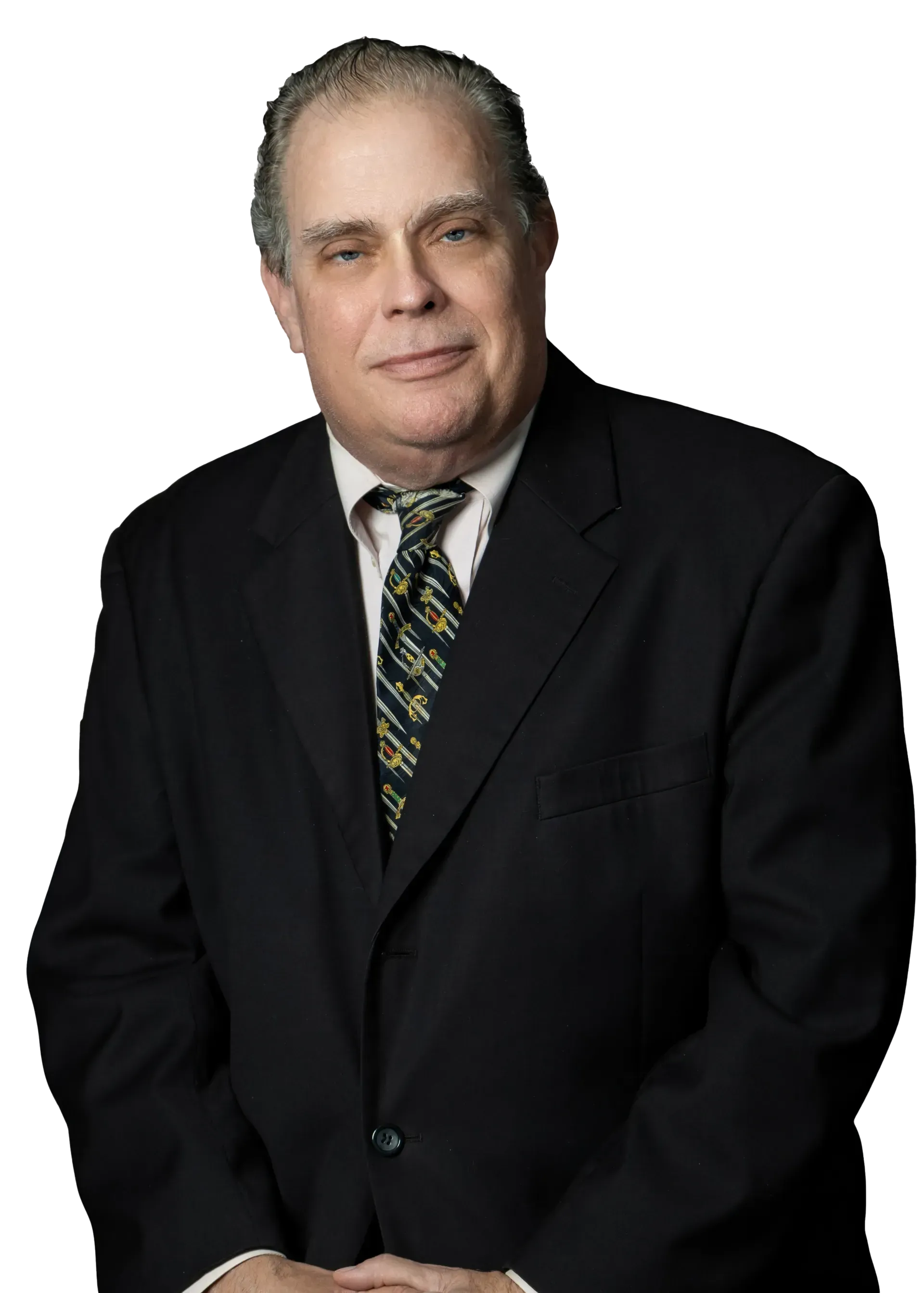 Man in black suit and tie, smiling, indoors.