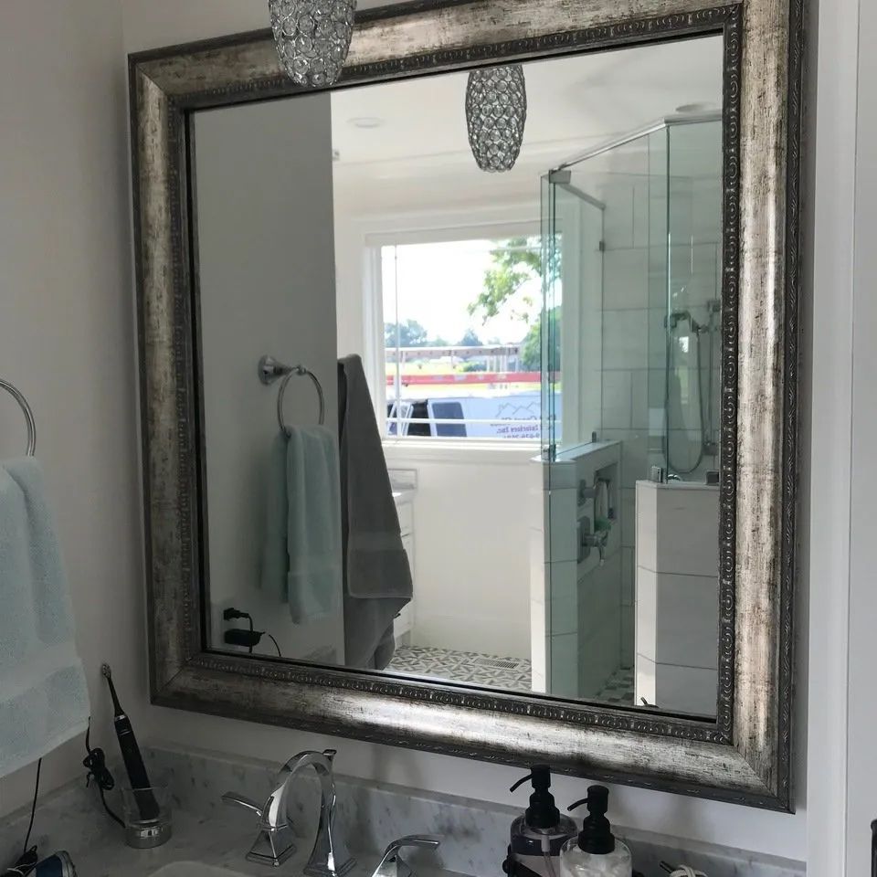 A bathroom with a large mirror and a sink