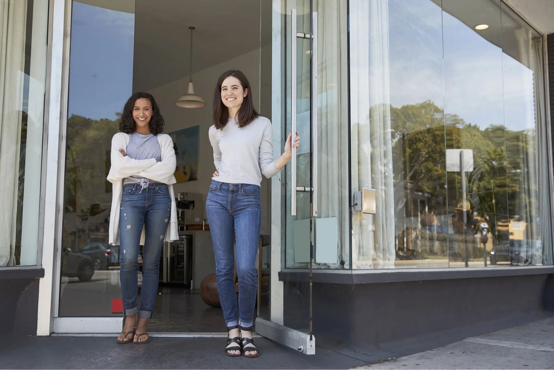 Two women are standing in the doorway of a store.