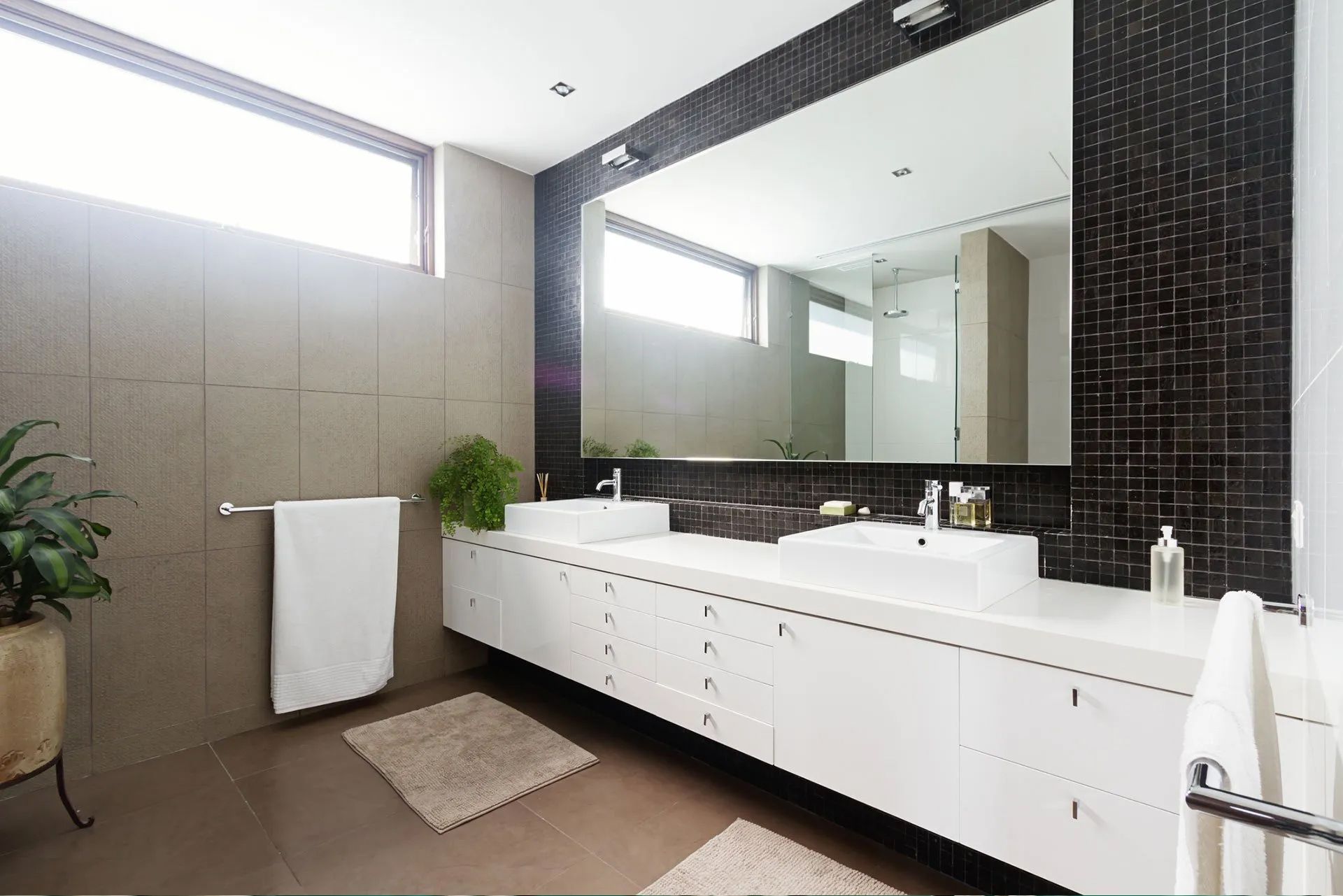 A bathroom with two sinks and a large mirror.