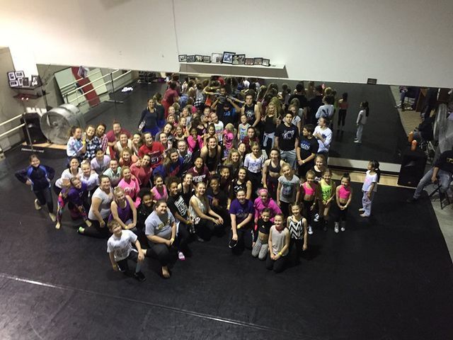 A large group of people are posing for a picture in a gym