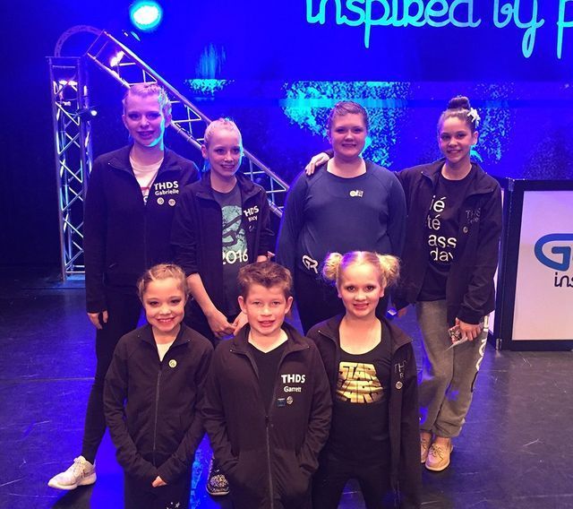 A group of people standing in front of a sign that says inspired by