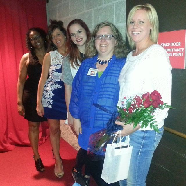 A group of women standing in front of a sign that says
