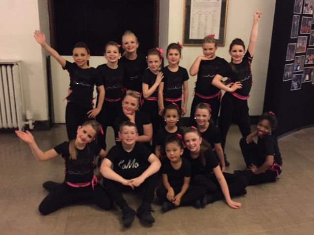 A group of children wearing black shirts with the word cello on them