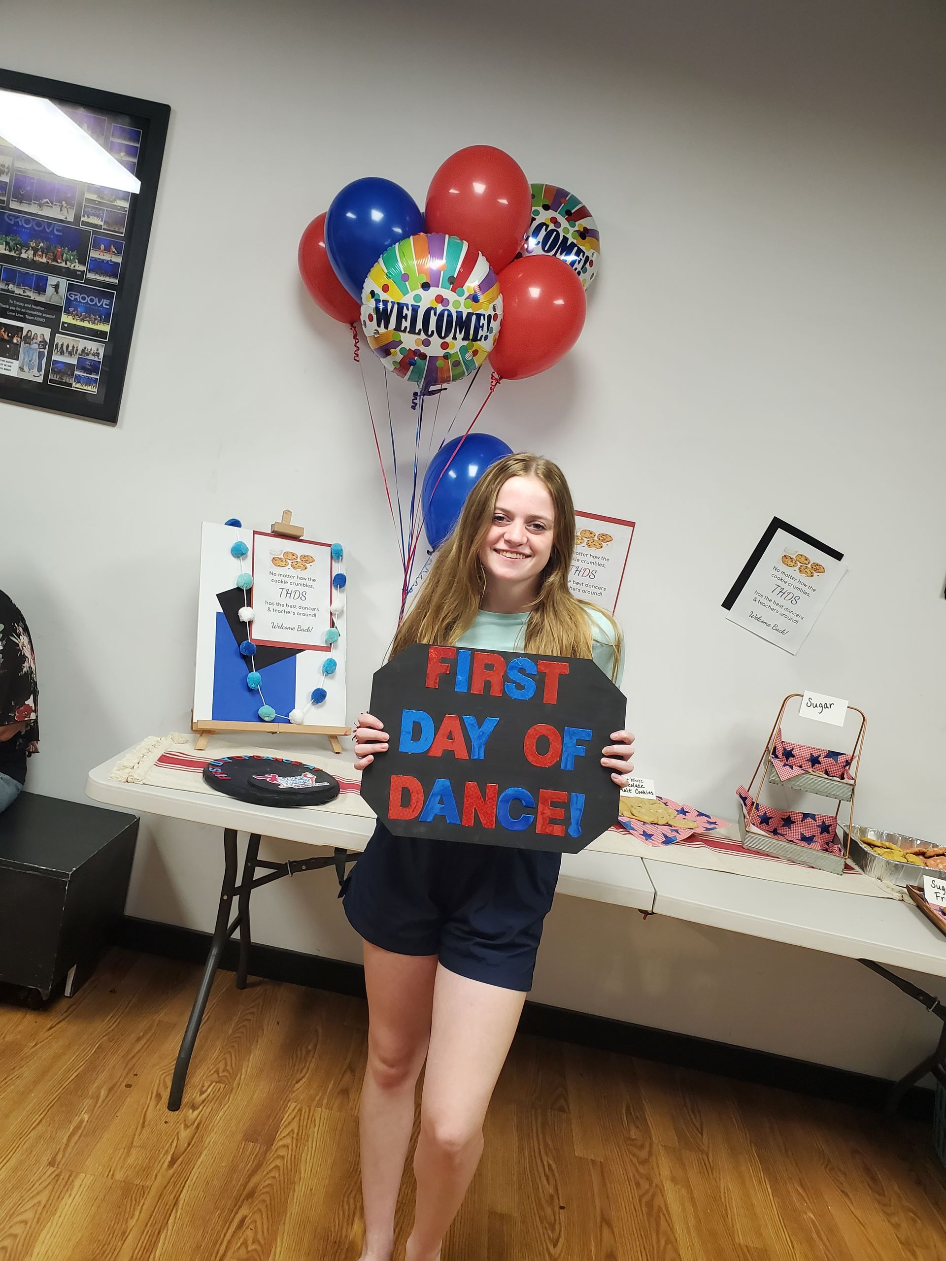 A woman is holding a sign that says first day of dance.