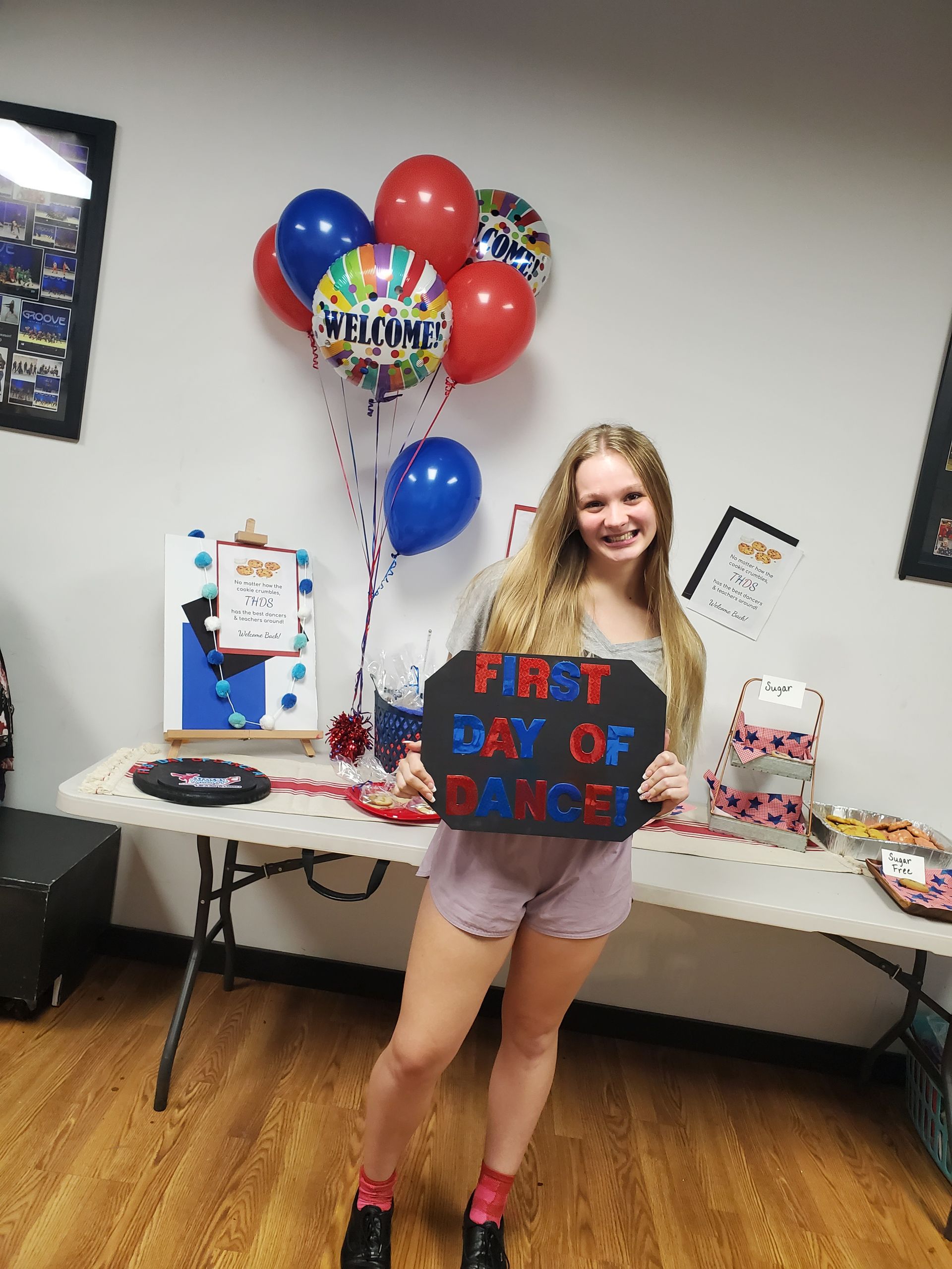 A girl is holding a sign that says first day of dance.