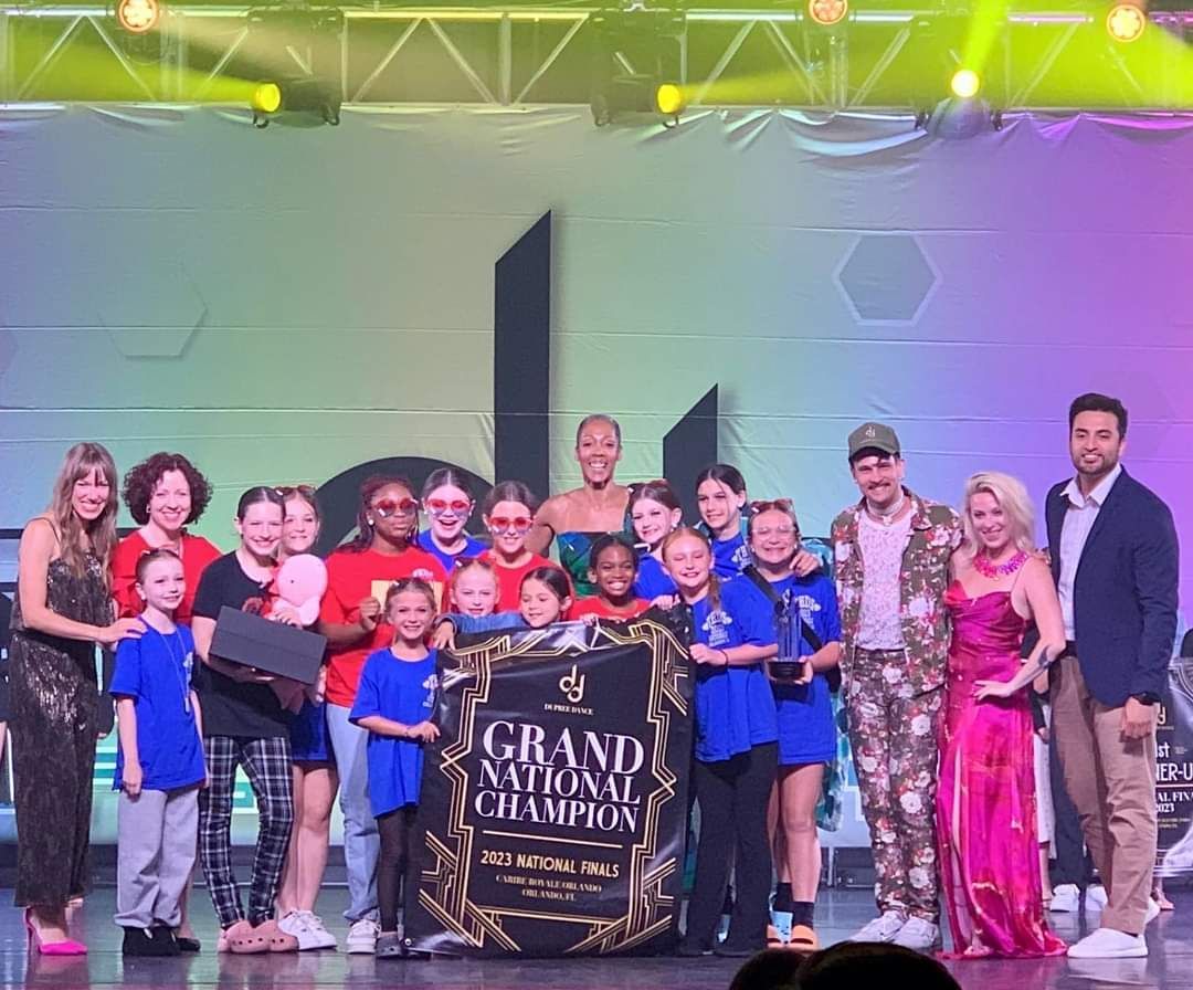 A group of people are posing for a picture on a stage.