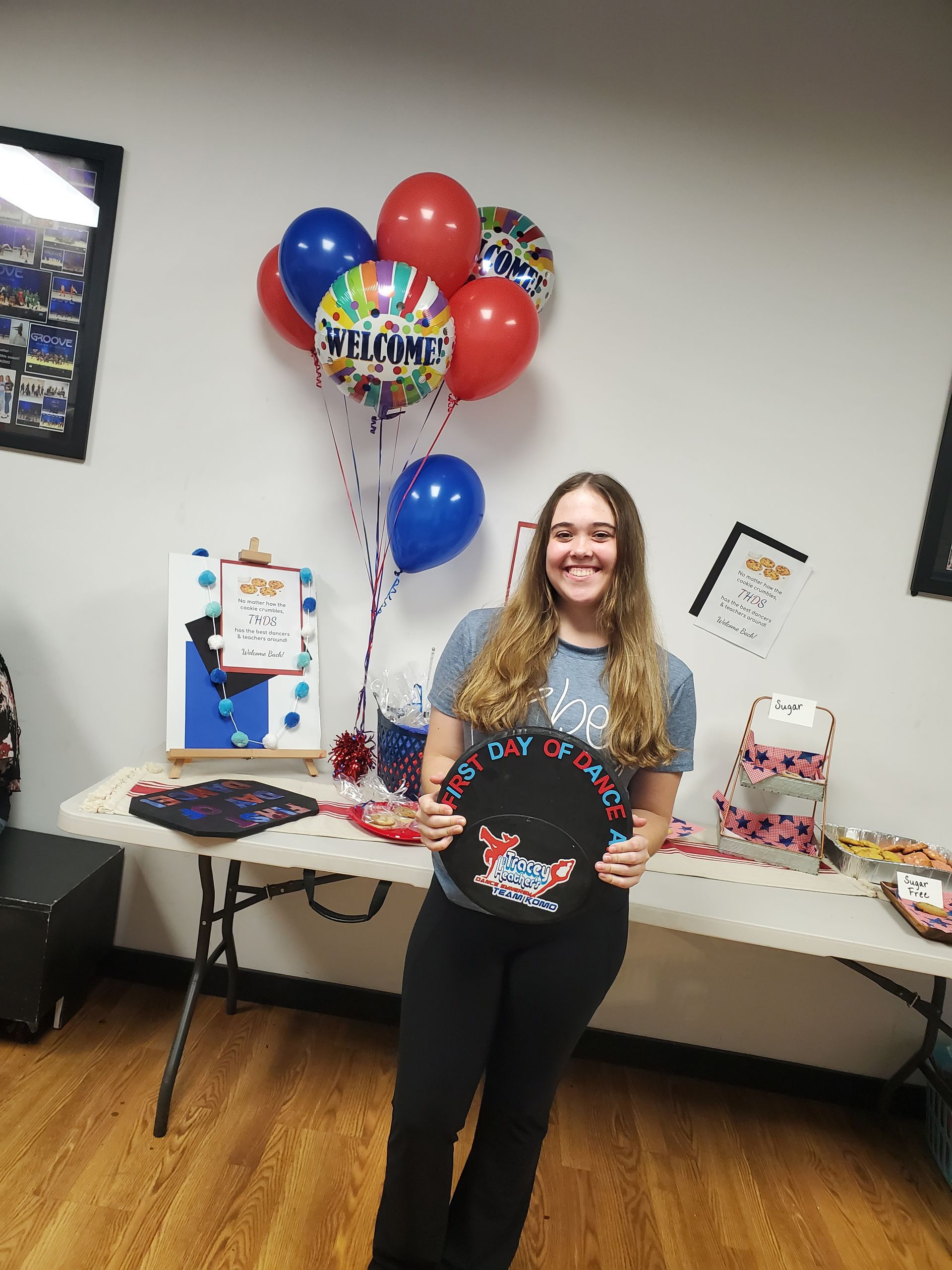 A woman is standing in front of a table with balloons.