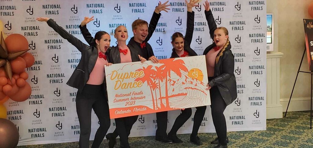 A group of people are holding up a sign that says flying dance