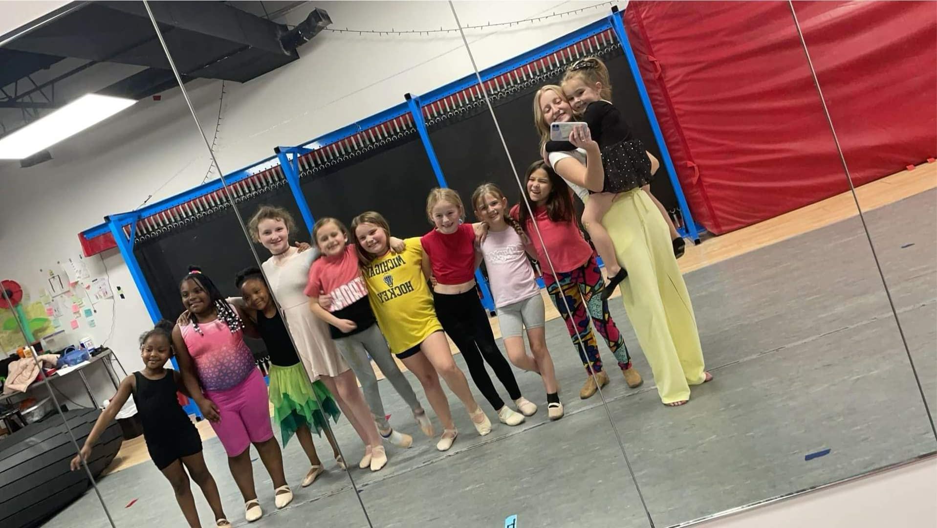A group of young girls are posing for a picture in a gym.