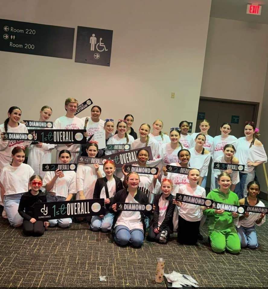 A group of young girls are posing for a picture in a room.