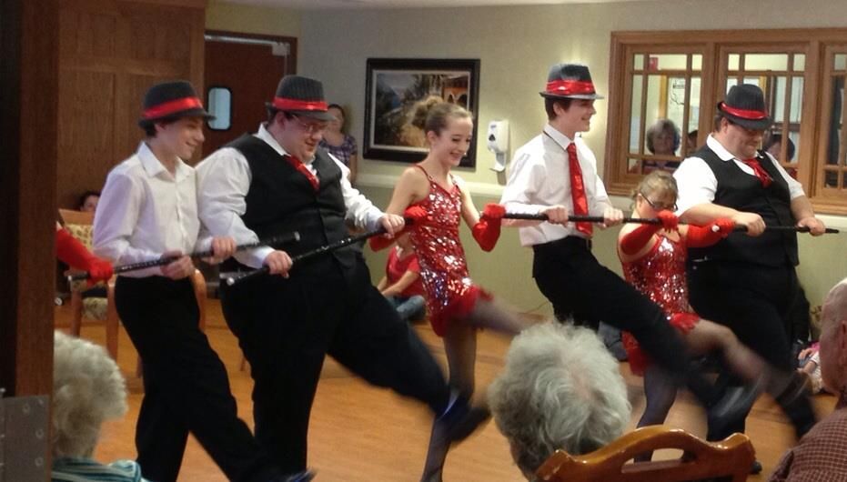 A group of people are dancing in a room