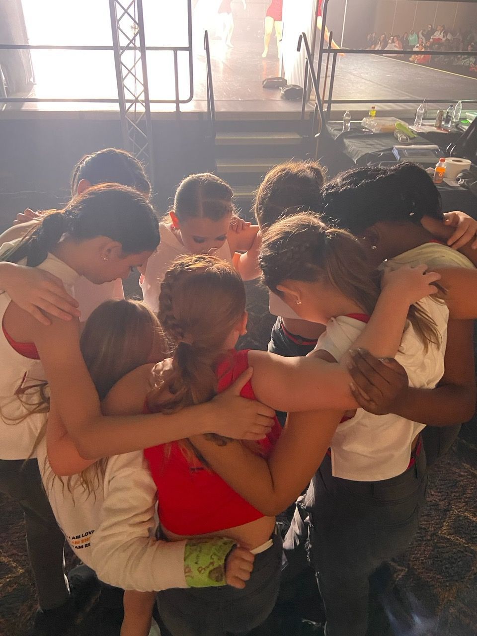 A group of children are hugging each other in a huddle.