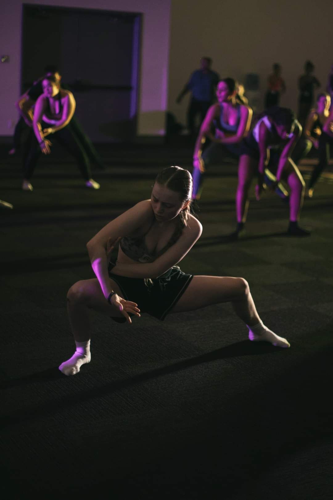 A group of people are dancing in a dark room