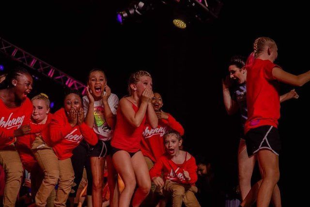 A group of young girls are dancing on a stage.