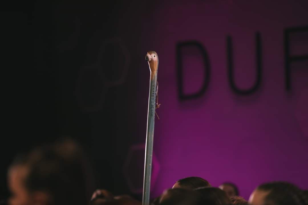 A group of people are standing in front of a sign that says duh