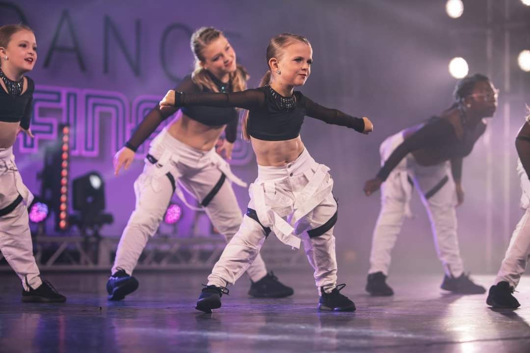 A group of young girls are dancing on a stage.