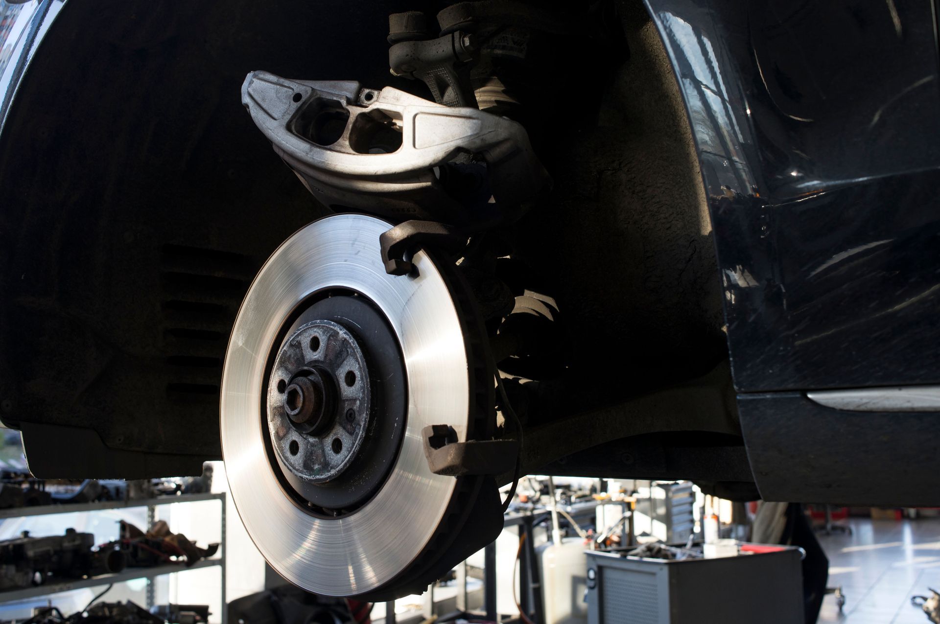 Close-up of an aircraft wheel and landing gear under a plane, with a shiny brake disc visible