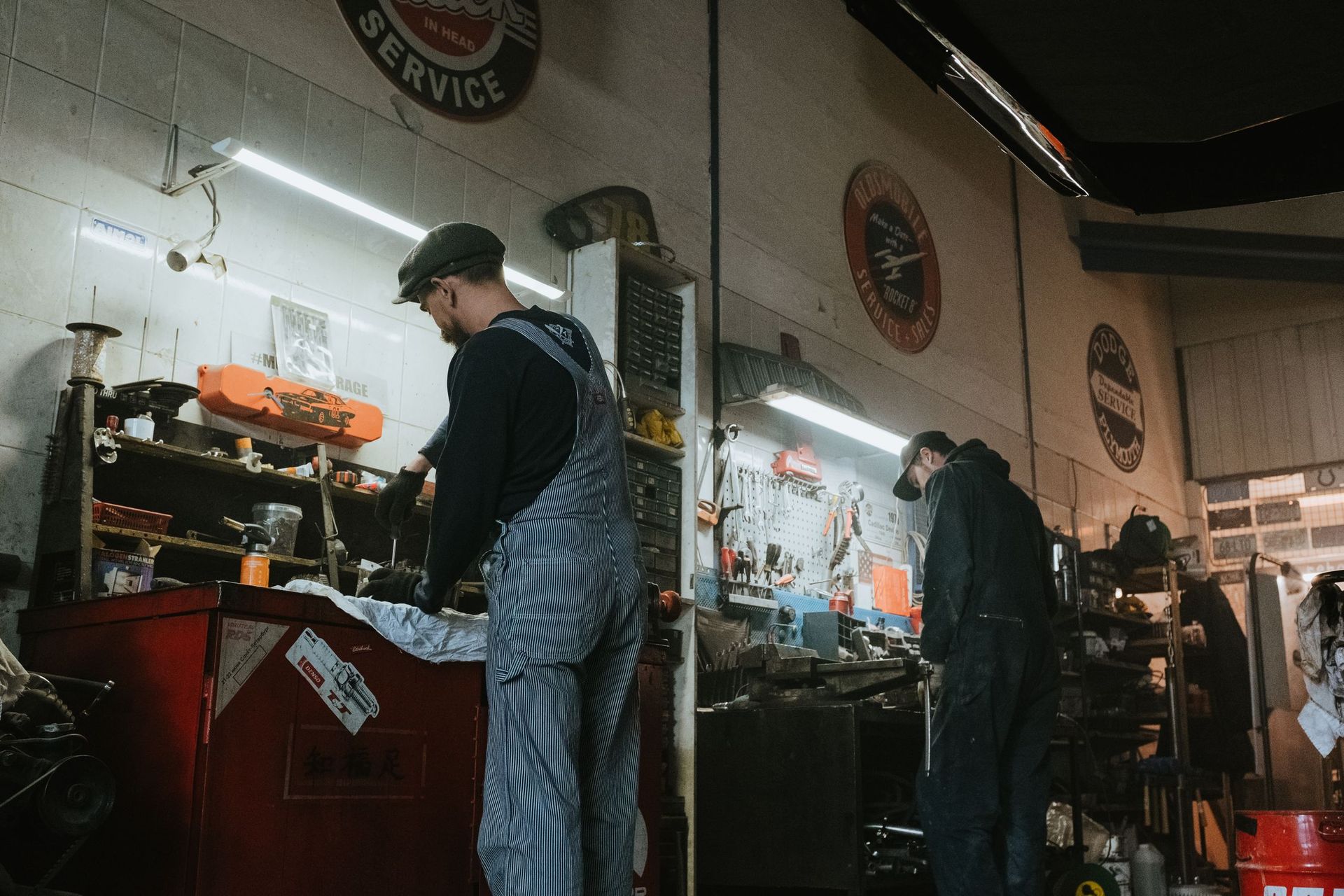 Barber shop interior with a person working at a counter under bright lights, tools and mirrors in view