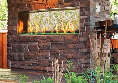 A countertop and a wall are covered in a stone mosaic. Behind is a lush, tropical landscape.