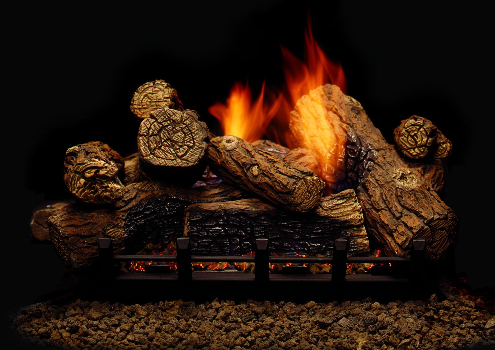 Gas fireplace with burning logs and orange flames against a dark background.