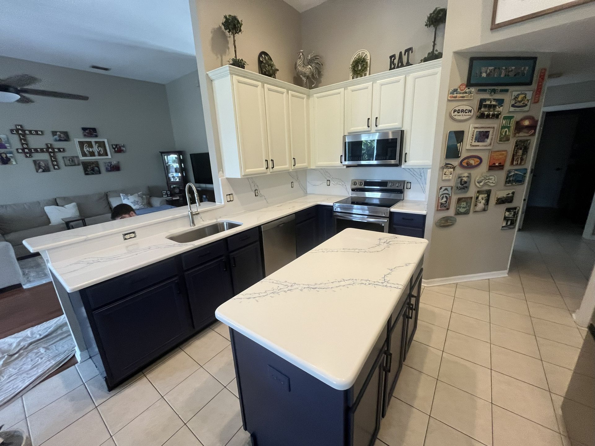 Kitchen with blue cabinets, white countertops, and stainless steel appliances.