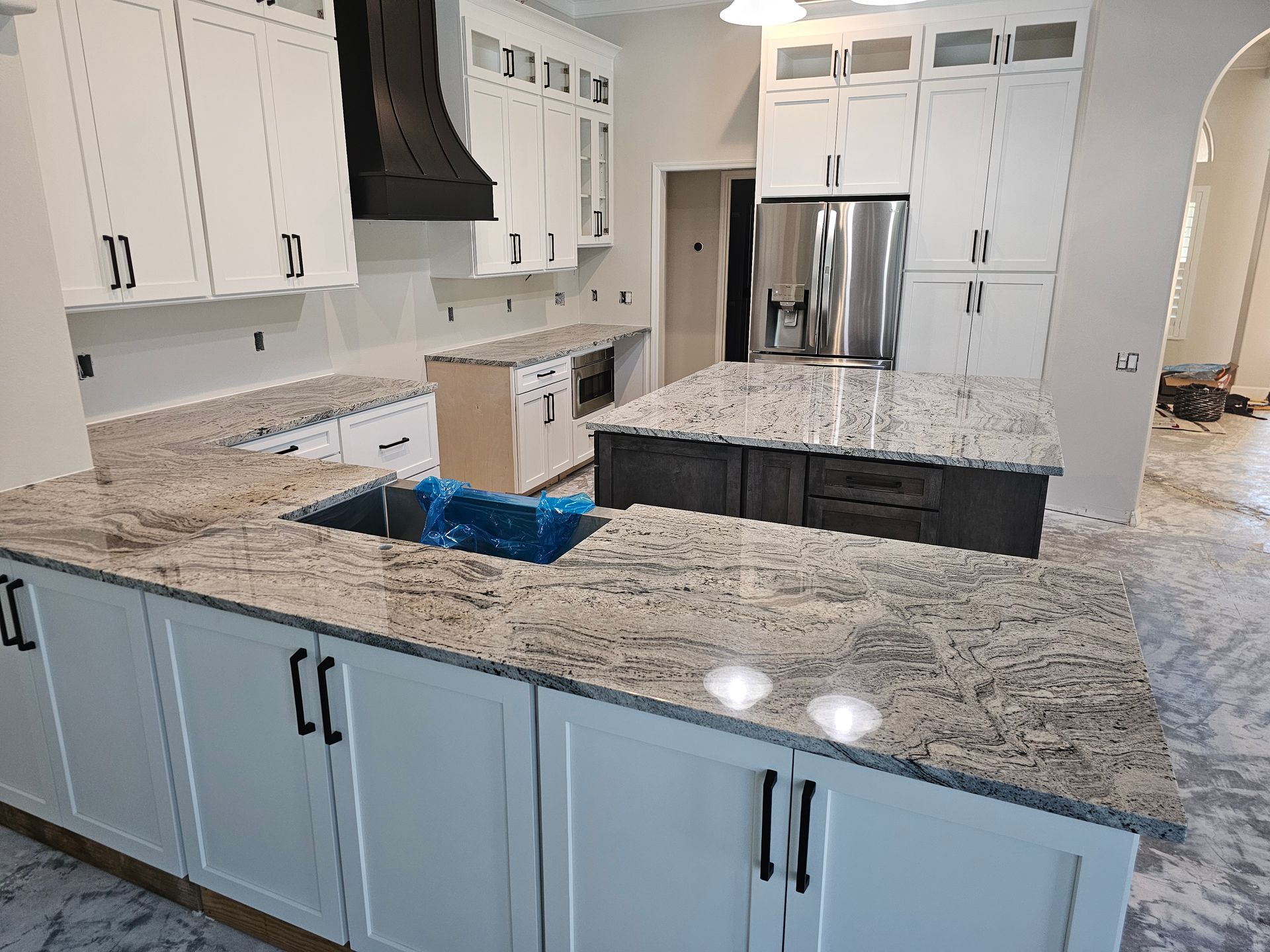 Newly renovated kitchen with white cabinets, granite countertops, and two islands.