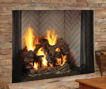 Gas fireplace with burning flames and decorative logs, set in a stone surround.