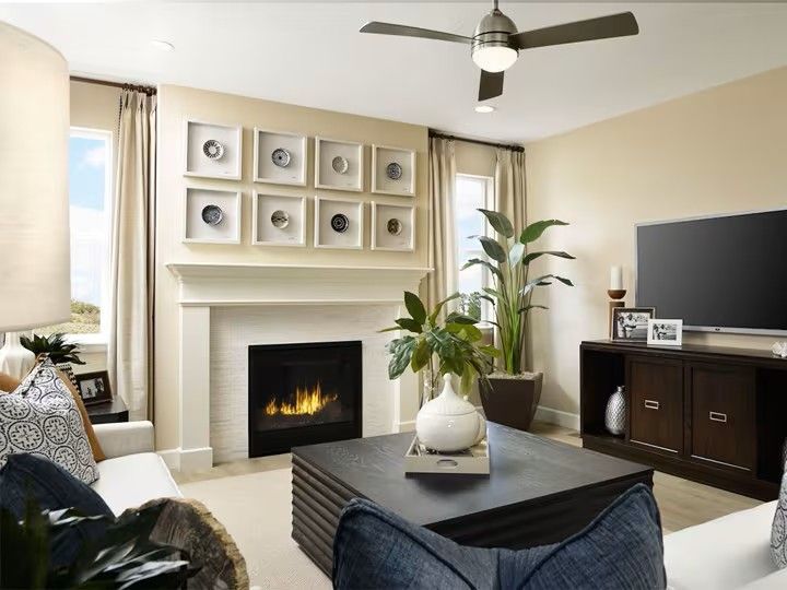Living room with fireplace, TV, and contemporary decor. Beige walls, white trim, dark wood furniture.