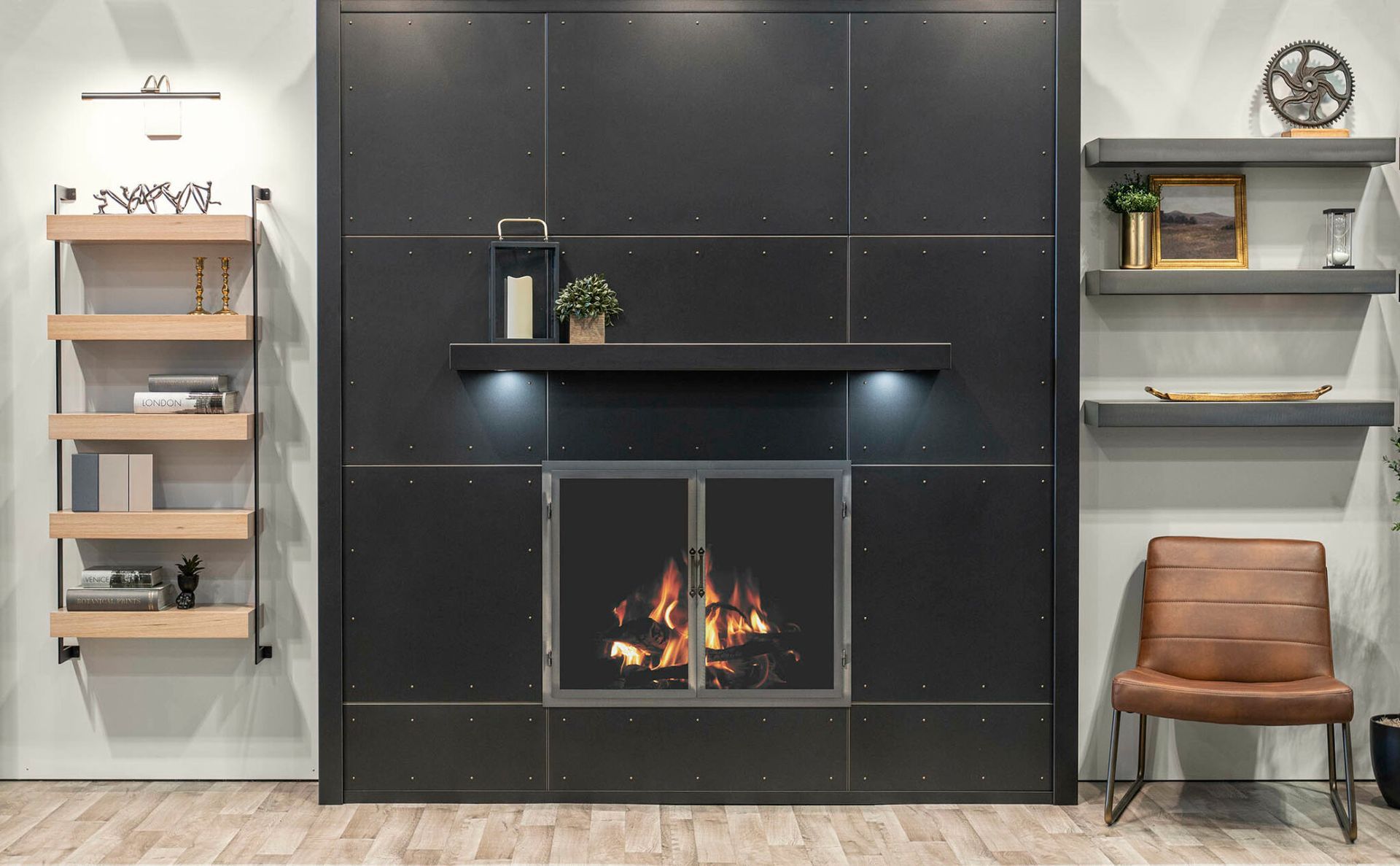 Black fireplace with fire, floating shelves with decor, and a leather chair.