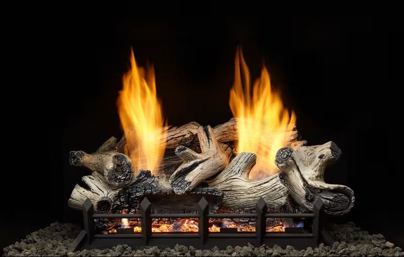 Fireplace with burning logs, flames in shades of orange and yellow, black backdrop.