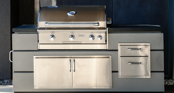 Stainless steel outdoor grill with cabinets and drawers.