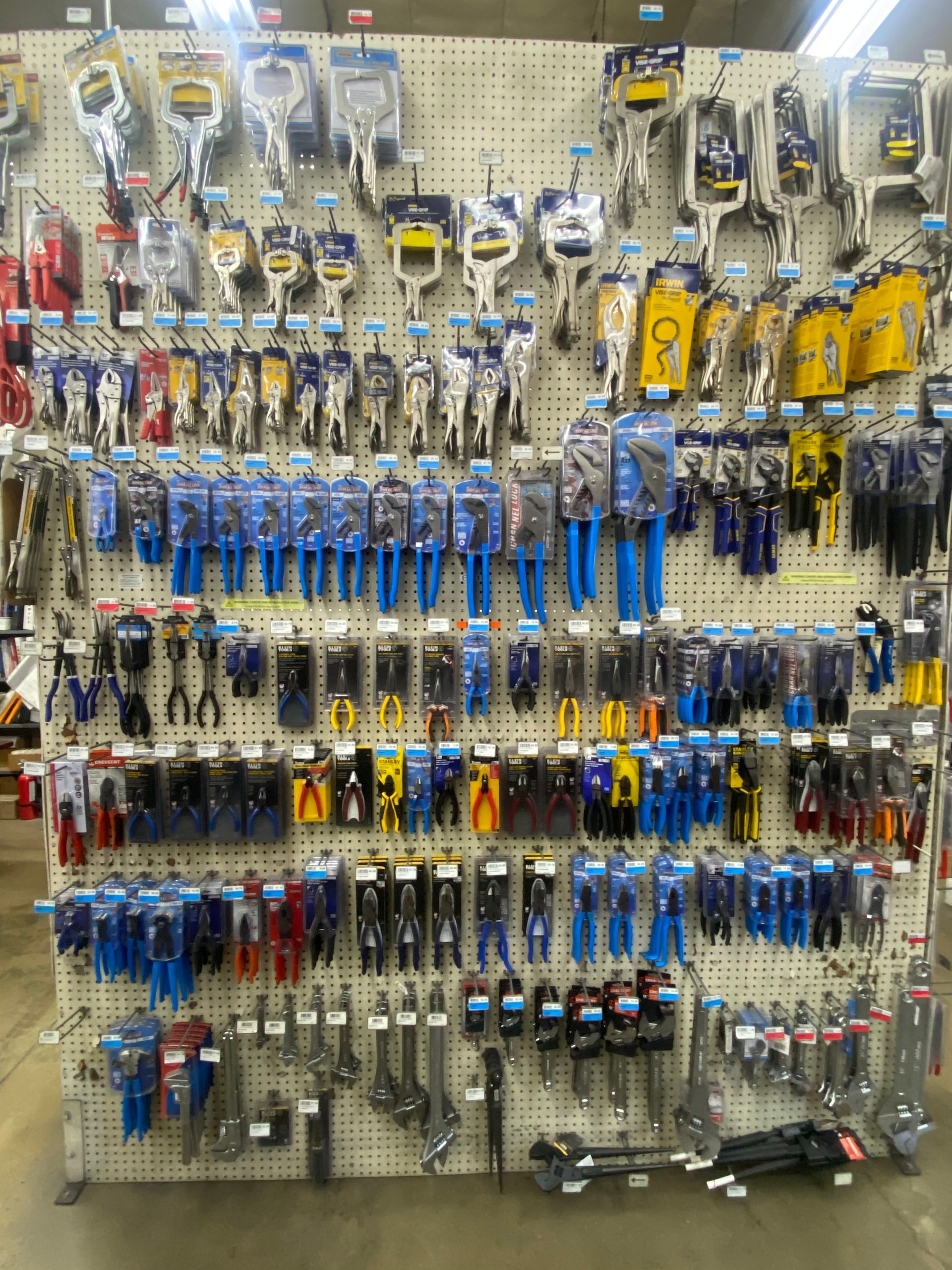 Workshop tools organized on a pegboard: wrenches, screwdrivers, pliers, drill, and vise.