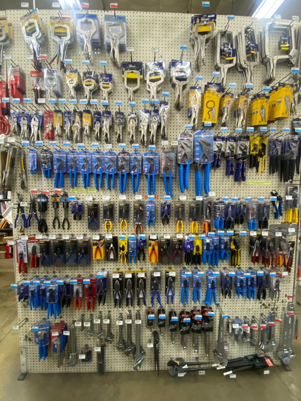 Workshop tools organized on a pegboard: wrenches, screwdrivers, pliers, drill, and vise.
