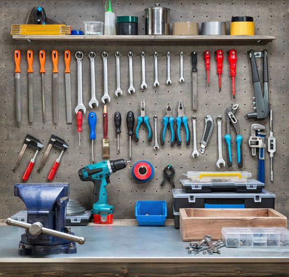 Workshop tools organized on a pegboard: wrenches, screwdrivers, pliers, drill, and vise.
