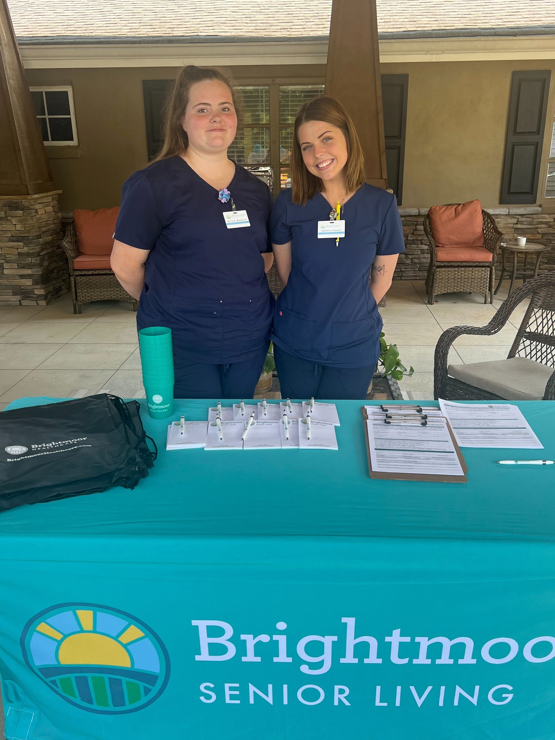 Two women standing in front of a brightmood senior living table