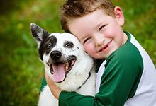 kid smiling with dog