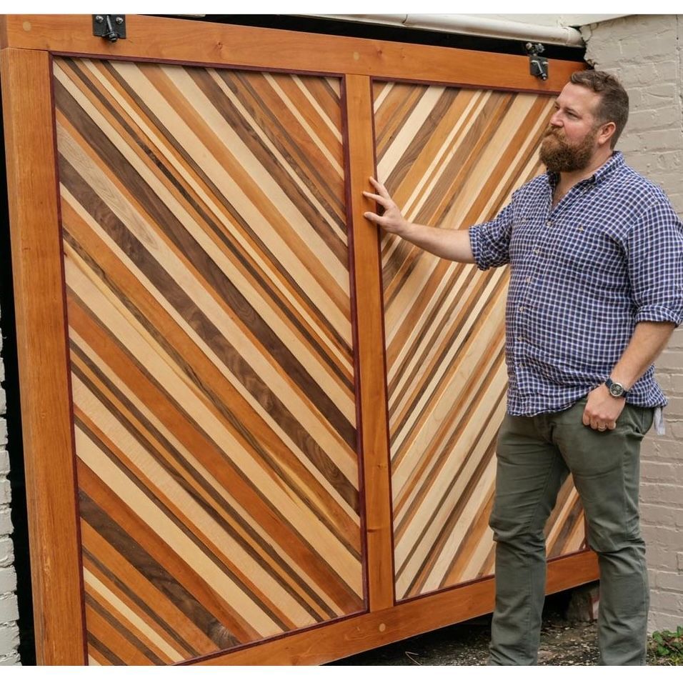 Man standing beside two diagonal-striped wooden sliding doors.